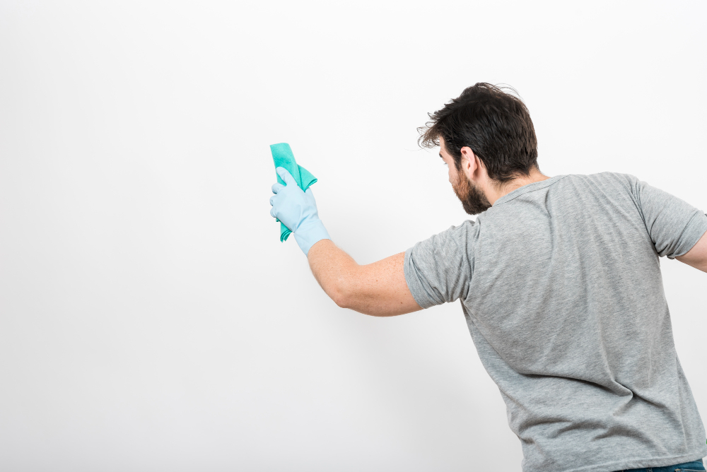 concept man cleaning his home with copyspace wall